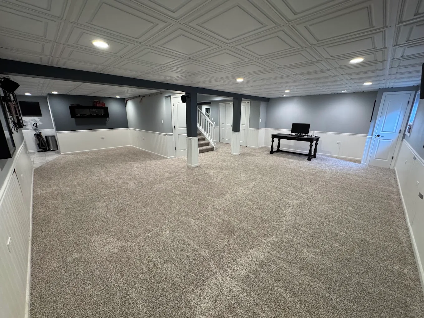 Finished basement living space with new wall-to-wall carpet installed by Premium Surfaces